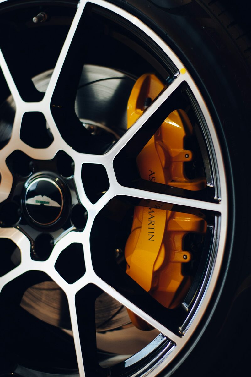 A clean dark alloy wheel with a yellow brake caliper