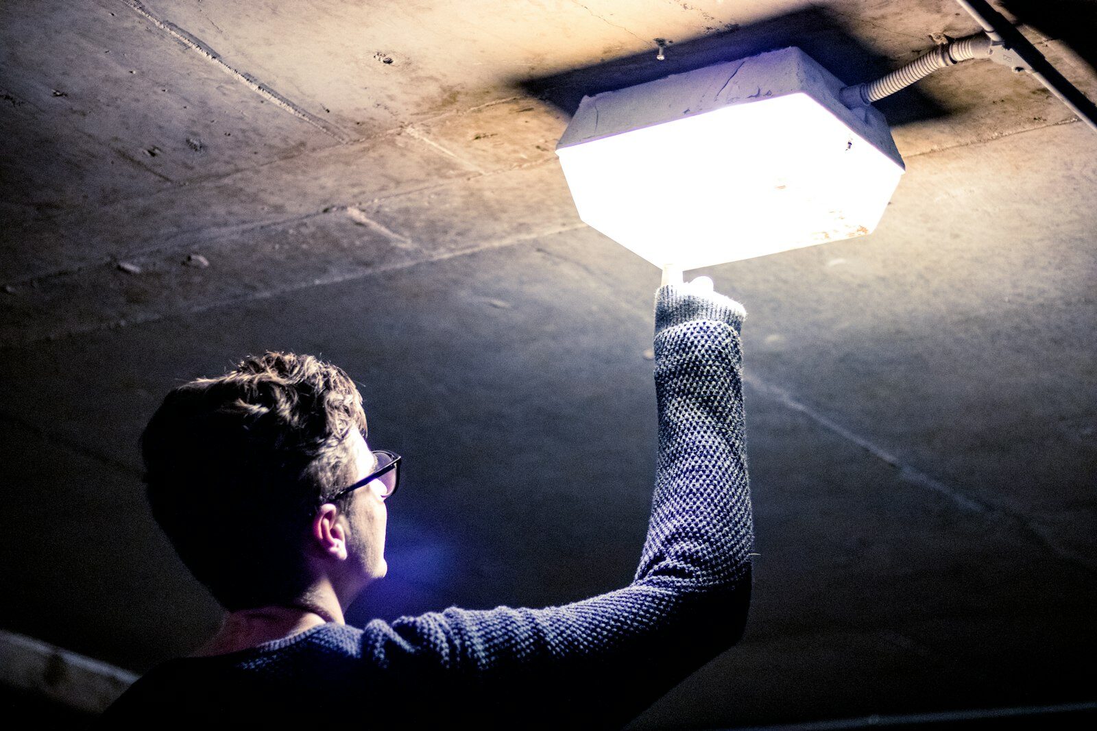 An engineer fitting a light fitting on site