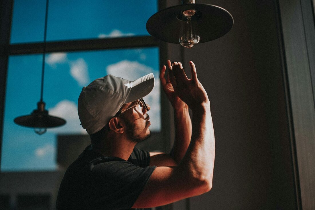 An electrician fitting a ceiling light