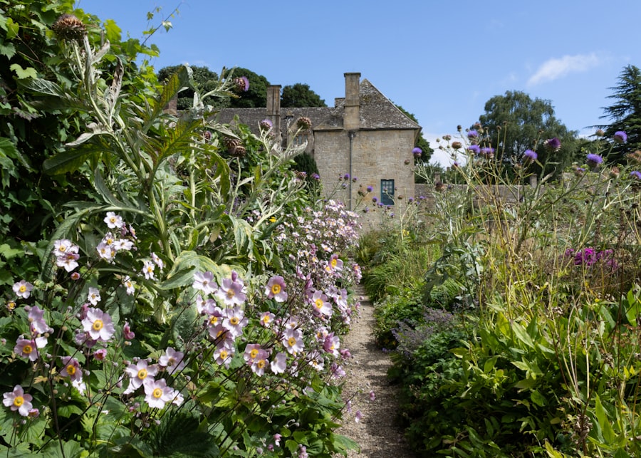 A cottage border full of flowers beside a stone path
