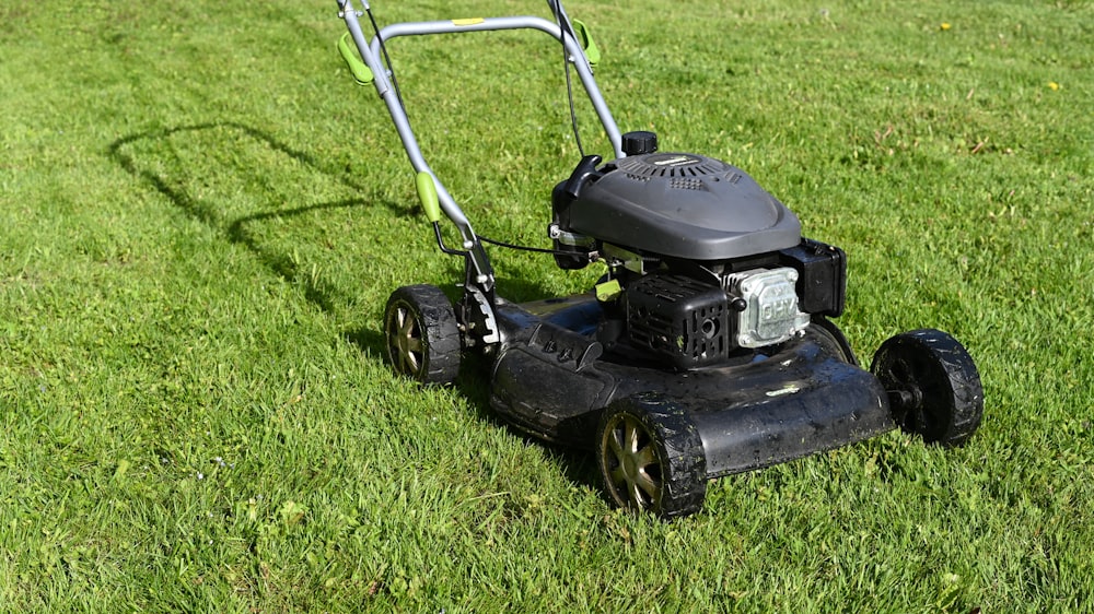 A mower cutting stripes into a green lawn