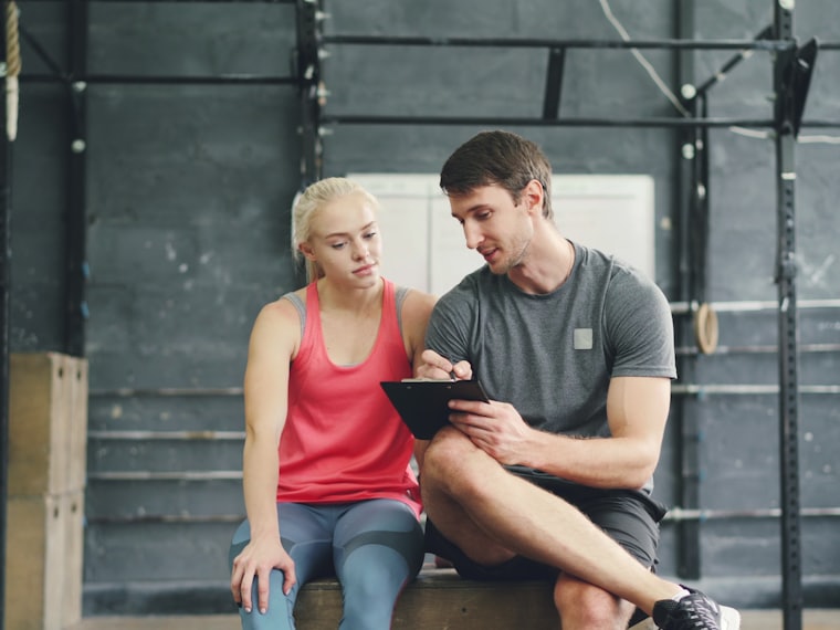 A coach sitting down with a new member to talk through their plan