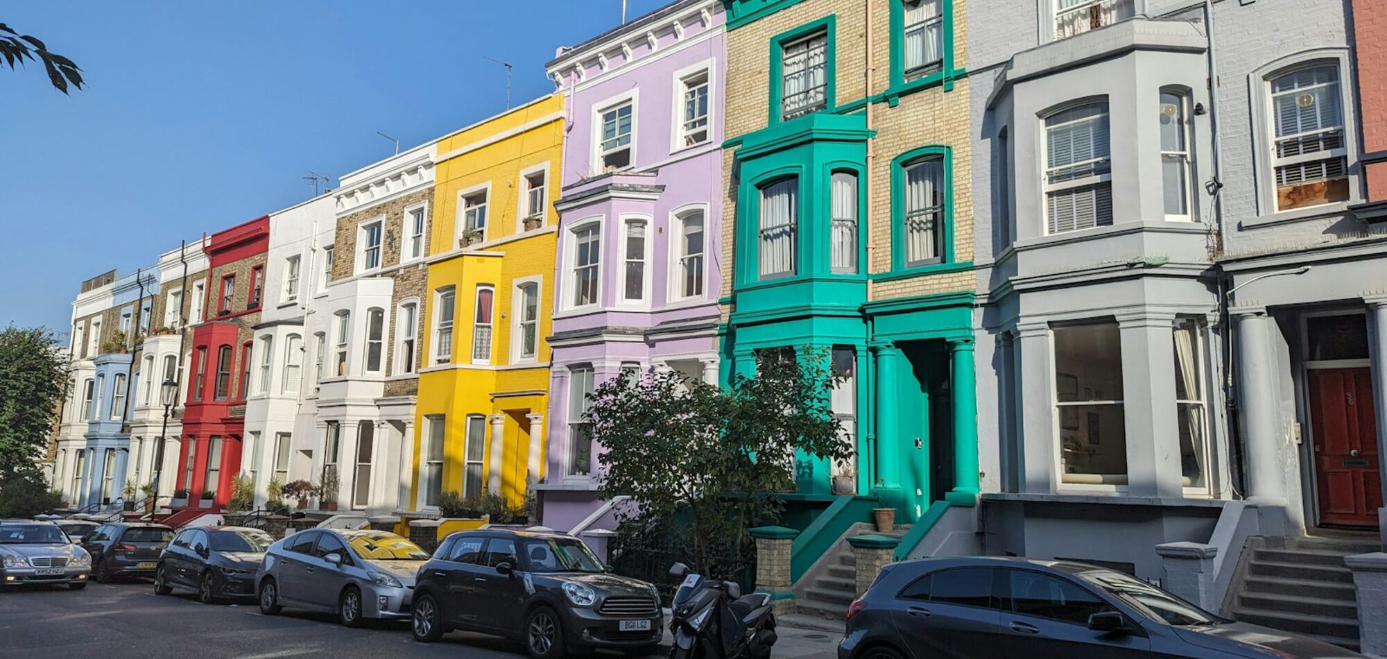 A row of painted terraced houses on a Millbrook street