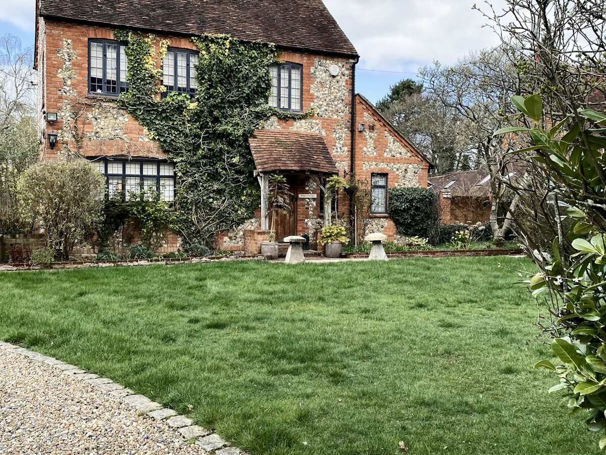 Brick and flint cottage with a front lawn