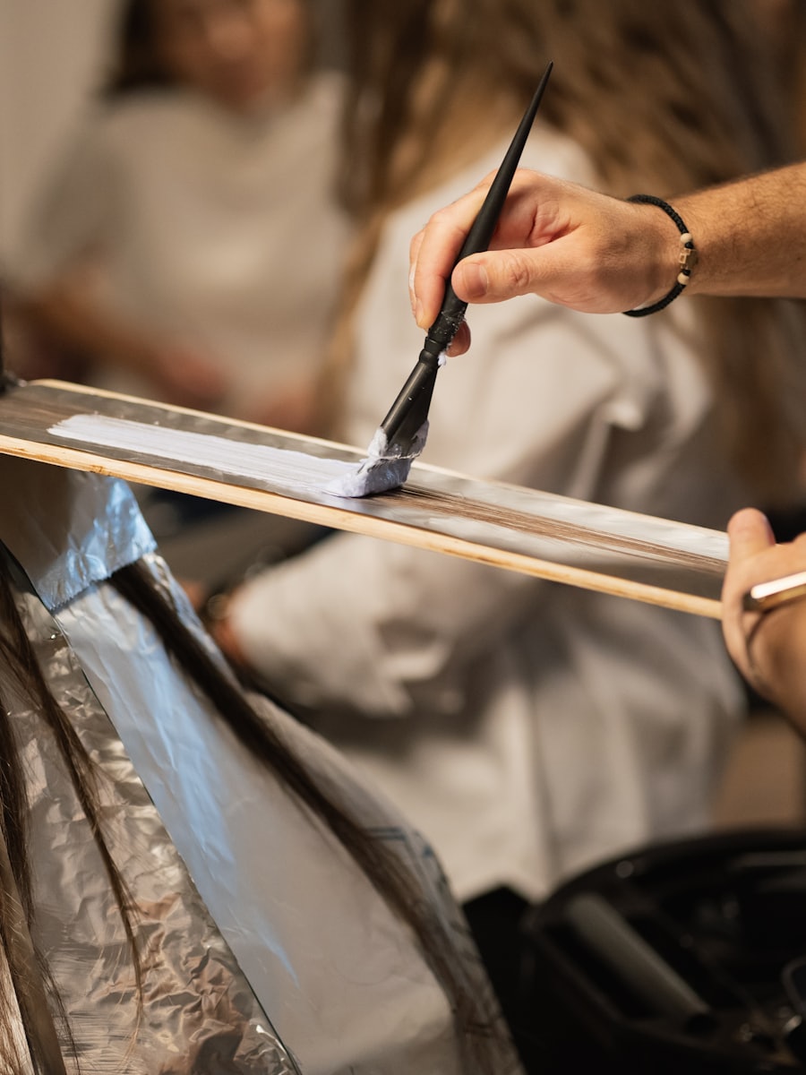 Colour being painted onto a section of hair by hand